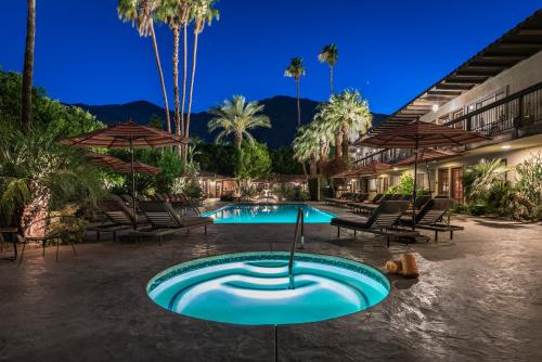 a pool at a resort with chairs and umbrellas at Santiago Resort - Palm Springs Premier Gay Men’s Resort in Palm Springs