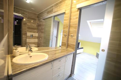 a bathroom with a sink and a mirror at Centrum Lux 2 Apartmanok in Kaposvár