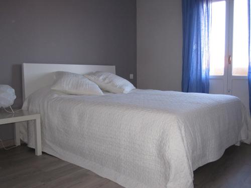 a bedroom with a white bed with pillows and a window at Piso centrico amplio-luminoso in Zarautz