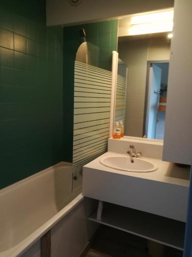 une salle de bain avec un lavabo, une baignoire et un miroir dans l'établissement Le Plein Soleil 2 510, à Orcières