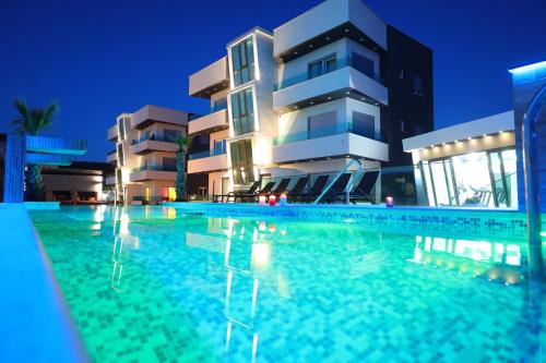 a swimming pool in front of a building at night at Boutique Apartments Ad Astra in Bibinje