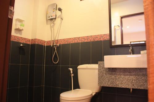 a bathroom with a shower and a toilet and a sink at Ming Shou Boutique House in Phuket Town