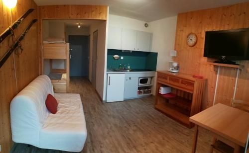 ein kleines Wohnzimmer mit einem weißen Sofa und einem TV in der Unterkunft Le Plein Soleil 2 510 in Orcières