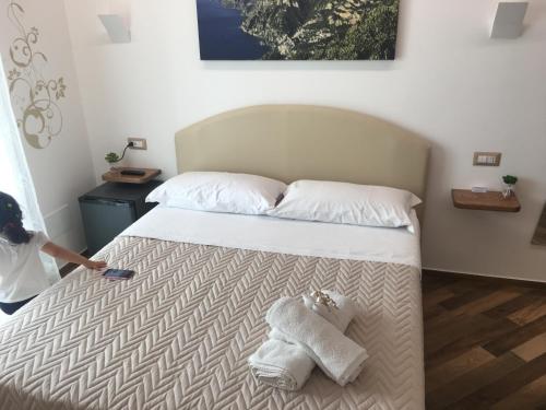 a woman is making a bed with towels on it at Il covo degli Dei in Agerola