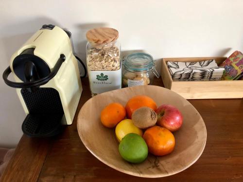 a bowl of fruit on a table next to a blender at Callemondah Studio with stunning views, in Bangalow and Byron Hinterland in Bangalow