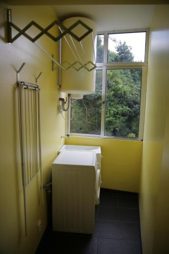 une salle de bains jaune avec chauffage et fenêtre dans l'établissement Braancamp 65, à Porto