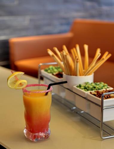 a drink sitting on a table with a tray of food at Best Western Alexander Park Chambéry in Chambéry