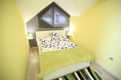 a small bedroom with a bed with a window at Centrum Lux 2 Apartmanok in Kaposvár