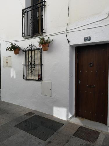 a white building with a door and a window at La casa del barrio in Mijas