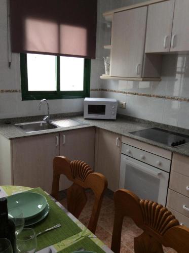 卡門港的住宿－Rubama，厨房配有桌椅和微波炉。