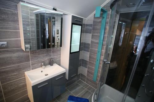 a bathroom with a sink and a shower at Centrum Lux 2 Apartmanok in Kaposvár