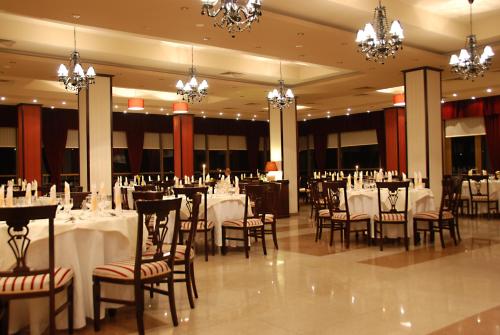 a banquet hall with white tables and chairs and chandeliers at Bucium Motel & SPA in Iaşi