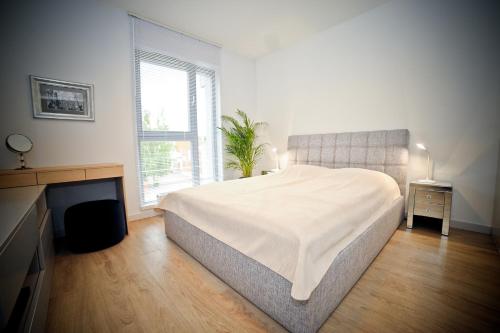ein weißes Schlafzimmer mit einem Bett und einem Kamin in der Unterkunft Luna Apartment Deluxe in Danzig