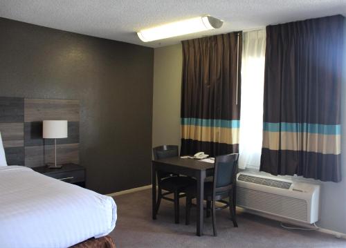 a hotel room with a bed and a table and chairs at Cozy Inn in Costa Mesa