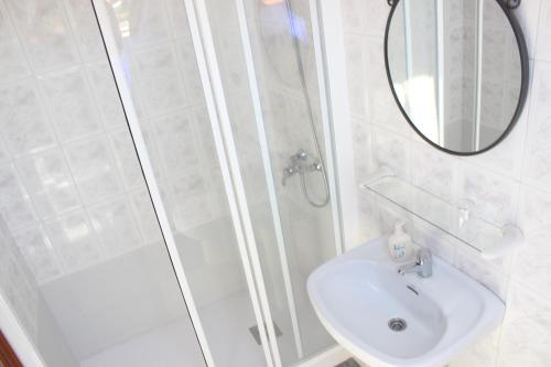 a bathroom with a shower and a sink and a mirror at O Cruceiro in Puentedeume