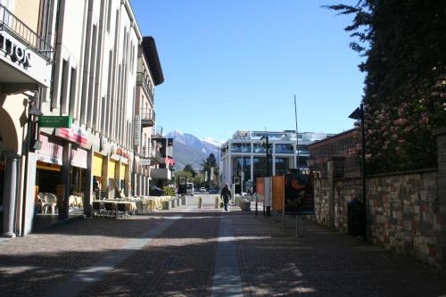 an empty city street with a person walking down the street at Apartment Irene - Casa Centro in Ascona