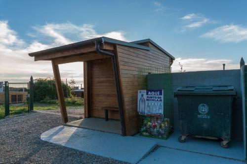a smallshed with a building next to a trash can at Cabañas La Misión in Niebla