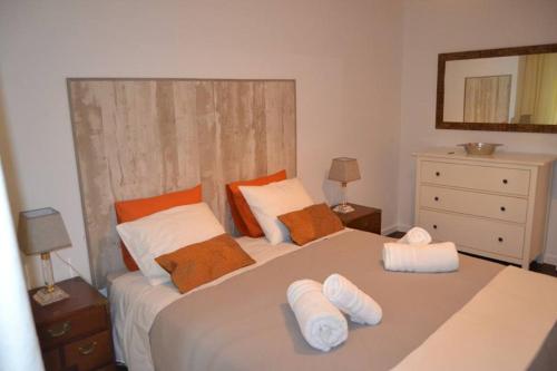 a bedroom with a large white bed with two pillows at Tuxas House in Braga