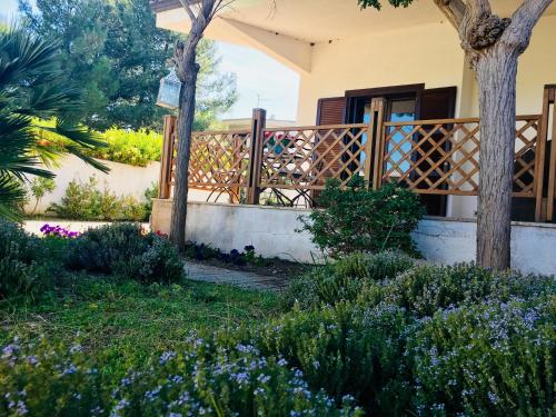 a house with a garden with purple flowers at Villa Lido Silvana Marina di Pulsano in Pulsano