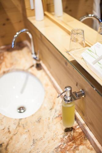 a bathroom counter with a sink and a bottle of soap at Landhaus am Stein in Bad Wiessee