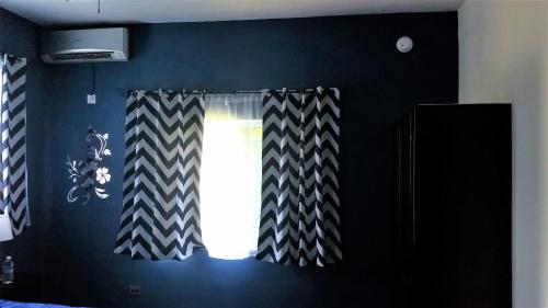 a room with a window with black and white curtains at Bailey's Bed and Breakfast in Runaway Bay