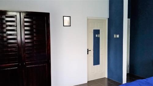 a bedroom with blue walls and a white door at Bailey's Bed and Breakfast in Runaway Bay