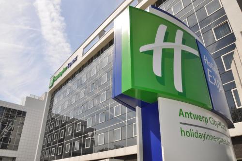 a green and white building with a sign on it at Holiday Inn Express Antwerpen City North, an IHG Hotel in Antwerp