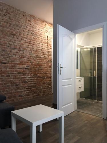 a living room with a white table and a brick wall at Ametyst Hostel in Krakow