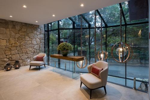 a room with two chairs and a table and windows at Villa Amistà Campos do Jordão in Campos do Jordão
