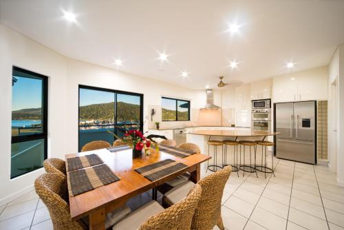a kitchen and dining room with a table and chairs at Portside Whitsunday Luxury Holiday Apartments in Airlie Beach