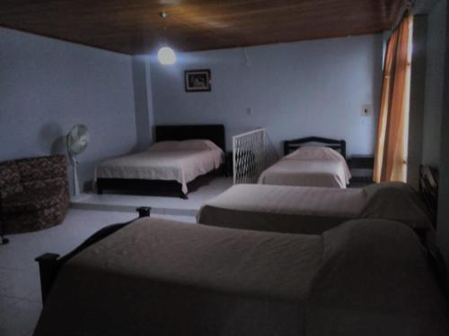 a bedroom with two beds and a couch in a room at Hotel Josemar in El Espinal