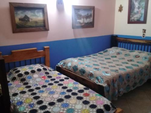 two beds in a room with blue walls at Hotel Atenas Jericó in Jericó