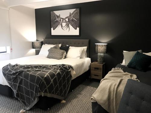 1 dormitorio con 2 camas y sofá en Ski Club of Victoria - Ivor Whittaker Lodge en Mount Buller