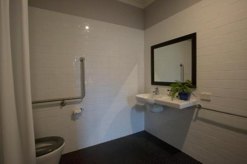 a bathroom with a sink and a toilet and a mirror at Seabreeze Hotel in Nelson Bay
