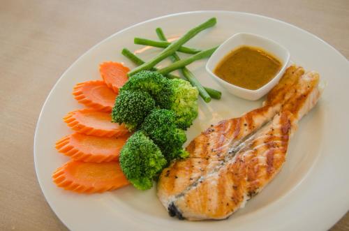 a plate of food with fish and vegetables and a dipping sauce at Casa Bella Phuket in Chalong 