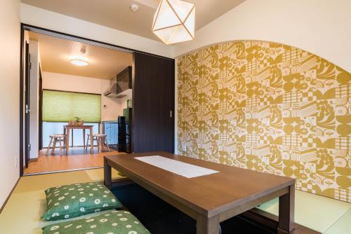 a dining room with a wooden table and a couch at Bijou Suites Kakomi in Osaka