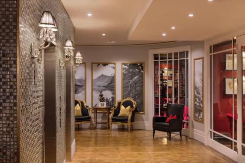 a hallway with chairs and a table in a room at Sofitel Queenstown Hotel & Spa in Queenstown