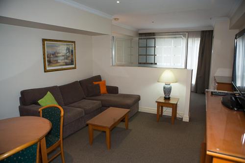 uma sala de estar com um sofá e uma mesa em Bond 215 Self-Catering em Sidney
