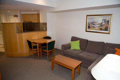 a living room with a couch and a table at Bond 215 Self-Catering in Sydney