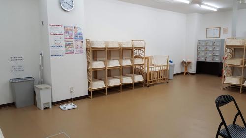 a room with many cribs and a clock on a wall at Toya-onsen Hotel Hanabi in Lake Toya