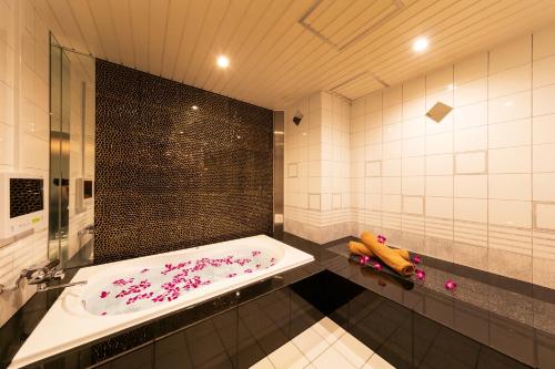 a bathroom with a tub with pink flowers on it at Hotel Eldia Luxury Kobe (Adult Only) in Kobe
