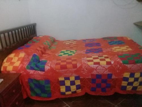 a bed with a colorful quilt on top of it at Hotel Atenas Jericó in Jericó