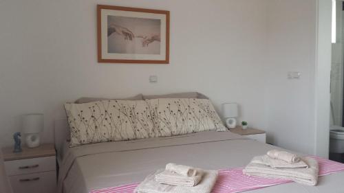 a bedroom with a bed with towels on it at Nina Villa in Rab