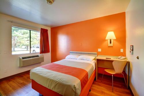 a bedroom with a bed and a desk and a window at Motel 6-Windsor Locks, CT - Hartford in Windsor Locks