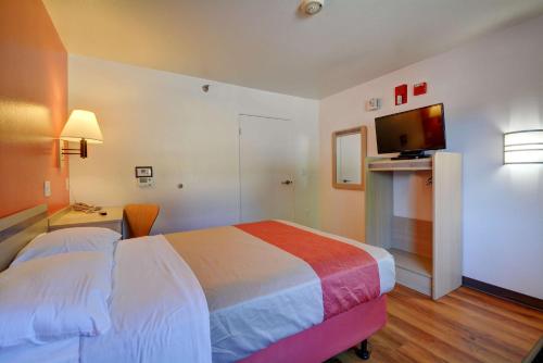 a hotel room with a bed and a flat screen tv at Motel 6-Windsor Locks, CT - Hartford in Windsor Locks