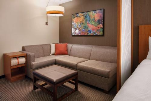 a living room with a couch and a bed at Hyatt Place Knoxville/Downtown in Knoxville