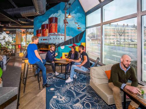 a group of people sitting at tables in a restaurant at Mercure Le Havre Centre Bassin Du Commerce in Le Havre
