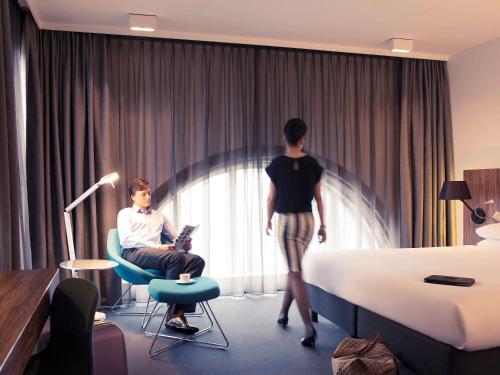 a man and a woman standing in a hotel room at Mercure Hotel Nijmegen Centre in Nijmegen