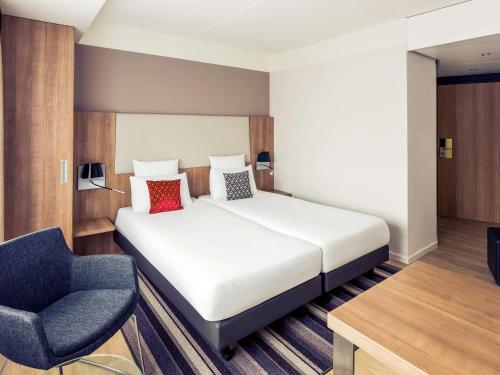 a hotel room with a bed and a chair at Mercure Hotel Nijmegen Centre in Nijmegen