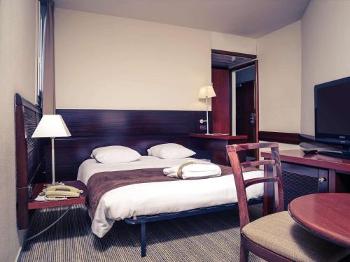 a hotel room with two beds and a desk and a table at Mercure Port La Grande Motte in La Grande-Motte